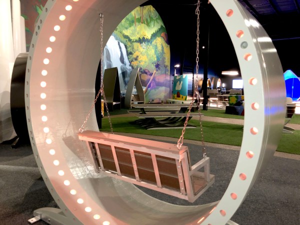 A swinging bench hangs inside a giant wheel that was formerly part of a wind turbine.